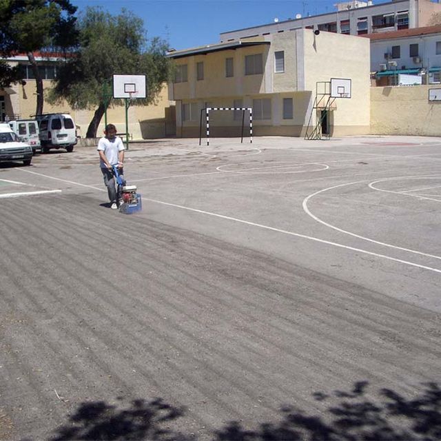 Aplitecme persona pavimentando cancha