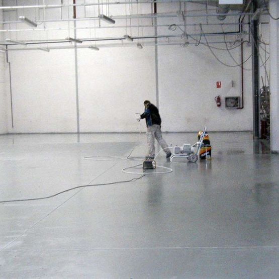 Aplitecme hombre pavimentando piso de fábrica